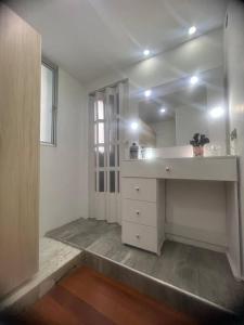 um quarto branco com um lavatório e uma janela em Galeras 103 em Bogotá