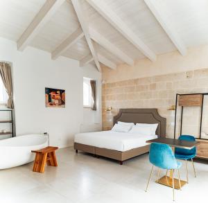 a bedroom with a bed and a desk and chairs at Le Vie Del Centro Luxury Room in Matera