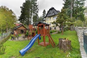 a playground in a yard with a slide at Willa Słoneczna Róża pokoje ze śniadaniami in Szklarska Poręba