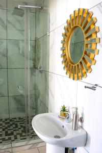 uma casa de banho com um lavatório e uma cabina de duche em vidro. em Suite Boutique Lodge em Pretoria