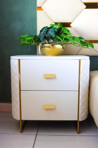 a white dresser with a plant on top of it at Suite Boutique Lodge in Pretoria