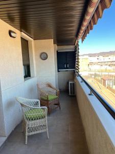 een balkon met 2 stoelen en uitzicht op de stad bij Apartamento Arcos Costa Cálida III in Águilas