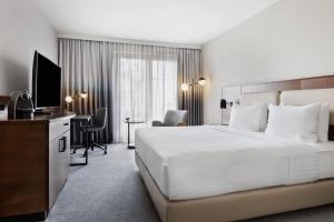 a hotel room with a large bed and a desk at Courtyard by Marriott Munich City East in Munich