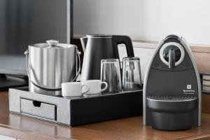 a black iron sitting on a counter with cups at Courtyard by Marriott Munich City East in Munich