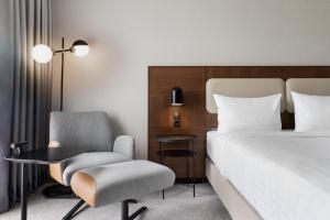 a hotel room with a bed and a chair and a desk at Courtyard by Marriott Munich City East in Munich