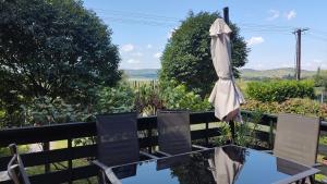 an umbrella sitting on a table with two chairs at Peace & Beach House in Tihany, Sajkod in Tihany