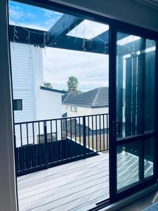 a view from a window of a porch with a deck at Stylish Industrial Holiday House in Pakuranga Free Wifi Netflix in Auckland