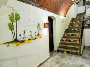 a staircase in a room with a painting on the wall at Hadouta Masreya Nubian Guest House in Aswan