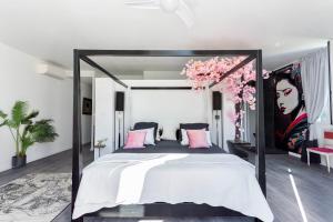 a bedroom with a large bed with pink pillows at Chambre d'hôtes de luxe, Toulon Mourillon, 4 belles chambres, Piscine in Toulon