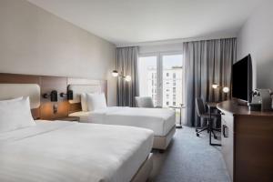 a hotel room with two beds and a television at Courtyard by Marriott Munich City East in Munich