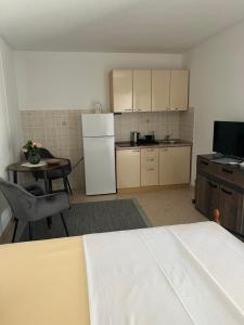 a small kitchen with a white refrigerator and a table at Leyla in Vodice