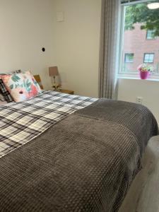 1 dormitorio con cama con almohada y ventana en Lugnt och centralt läge en Borås