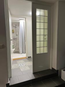 baño con ducha y puerta que conduce a la bañera en Lugnt och centralt läge en Borås