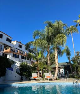 a swimming pool with palm trees and a building at La Pina Verde in Estepona