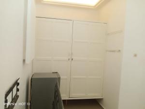 een witte kast in een kamer met een koelkast bij HEBERTOGO Casablanca in Lomé