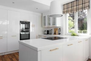 una cocina blanca con armarios blancos y fregadero en 5 rooms villa with heated pool and fireplace, 
