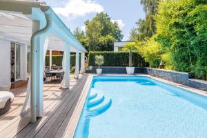 una piscina en un patio trasero con terraza de madera en 5 rooms villa with heated pool and fireplace, 