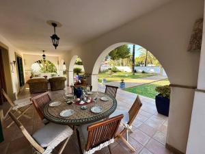 comedor con mesa y sillas en Chalet Villa Mediterránea a 75 metros de la playa. en Orihuela