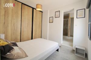 - une chambre avec un lit blanc et un mur en bois dans l'établissement LA PASTISSIERE BIS - 4 COUCHAGES, à Carry-le-Rouet