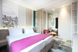 una camera da letto con un grande letto con una coperta rosa di Hotel Cosmopolit a Sarajevo
