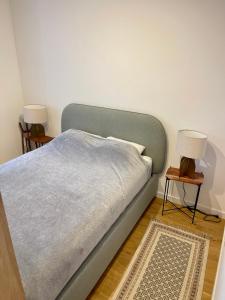 1 cama con manta azul y 2 mesitas de noche en Time&House Pileckiego przy centrum Onkologi i klinice Novum Apartament na wyłączność pokój,sypialnia,łóżko, łazienka,kuchnia, en Varsovia