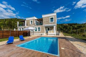 a villa with a swimming pool and a house at Villa Vera in Agios Nikitas