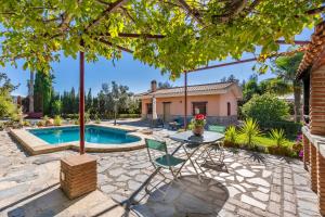 a backyard with a pool and a table and a house at Casa rural a pie de Sierra Nigüelas in Nigüelas