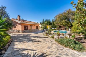 a driveway leading to a house with a swimming pool at Casa rural a pie de Sierra Nigüelas in Nigüelas