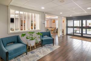 a living room with two blue chairs and a table at Comfort Inn Airport in South Portland