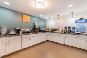 a large kitchen with white cabinets and appliances at Comfort Inn Airport in South Portland