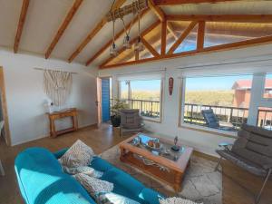 a living room with a blue couch and a large window at Alojamiento en Cáhuil, Pichilemu in Pichilemu