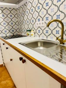 a kitchen with a sink and blue and white tiles at Apartamentos rurales, La Casa de Baltasar in Fondón