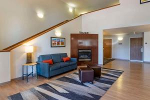 a living room with a blue couch and a fireplace at Comfort Inn & Suites Beaver - Interstate 15 North in Beaver