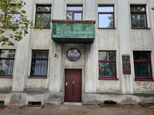 - un bâtiment avec une porte rouge et des fenêtres dans l'établissement Kambarys centre prie funikulieriaus #4, à Kaunas