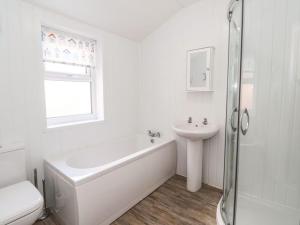 Un baño blanco con bañera y lavabo. en Stella’s secret, en Bridlington 9 fotos más