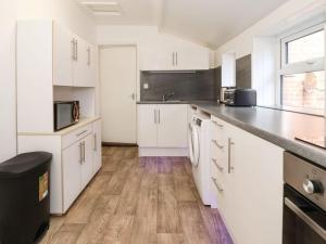 a kitchen with white cabinets and a counter top at Stella’s secret in Bridlington