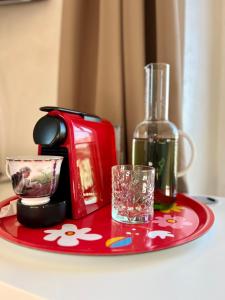 a red plate with a bottle of wine and a glass at Tricolore Suite in Milan