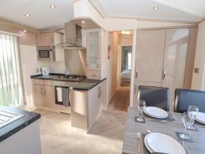 a kitchen and dining room with a table and chairs at No 35 Meadows Retreat Lodge Park in Cockermouth
