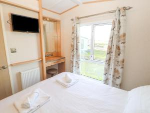 a bedroom with a bed and a window at No 35 Meadows Retreat Lodge Park in Cockermouth