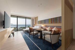 a living room with a couch and a table and chairs at Hyatt Regency Sanya Tianli Bay in Sanya