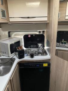 an rv kitchen with a stove and a microwave at Campers Reyna in Arrecife