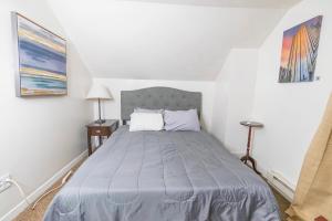 a bedroom with a bed with a blue comforter at 1 BR - Parking - Amazing View Nearby! in Pittsburgh