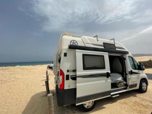un camper bianco parcheggiato sulla spiaggia di Campers Reyna ad Arrecife