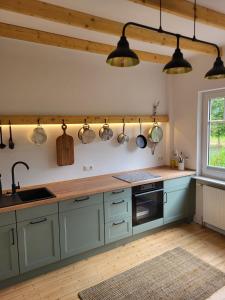 a kitchen with blue cabinets and pots and pans on the wall at Oma's Huus Ostfriesland 2-6 P in Moormerland