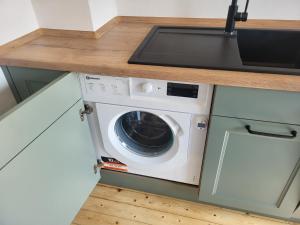 a washer and dryer in a kitchen under a counter at Oma's Huus Ostfriesland 2-6 P in Moormerland