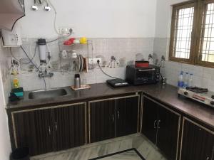 uma cozinha com um lavatório e um micro-ondas em 9Backpackers Dehradun em Dehradun