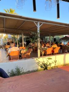 un grupo de personas sentadas en un restaurante al aire libre en Mavi Cennet Camping&Pansiyon, en Kızılot