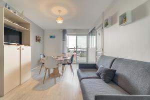 a living room with a couch and a table at Appartement vue Mer in Saint-Cast-le-Guildo