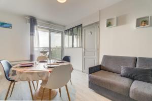 a living room with a table and a couch at Appartement vue Mer in Saint-Cast-le-Guildo