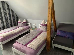 ein Zimmer mit zwei Betten und einem Stuhl in der Unterkunft Fewo Lindenlaub in Brotterode